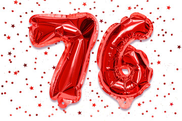 The number of the balloon made of red foil, the number seventy six on a white background with sequins. Birthday greeting card with inscription 76. Numerical digit, Celebration event.