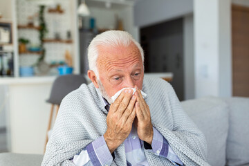 New coronavirus CoVid-19 outbreak situation with pandemic epidemic warning - adult caucasian senior old man with fever symptoms like illness cold seasonal influenza - people and virus concept