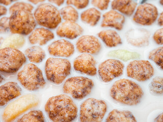 Corn balls in milk close-up. Healthy breakfast of corn flakes and milk.
