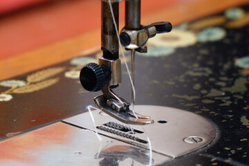 Sewing needle with thread on a sewing machine. Soft focus. Selective focus