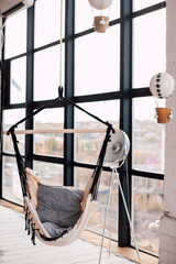 Swing hammock indoors near a large panoramic window