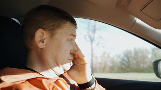 Tired sleepy driver rubs his eyes while driving. Transport safety.