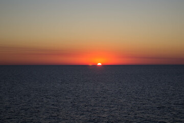 evocative image of sunset over the calm sea on a beautiful day