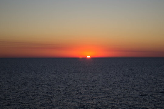 evocative image of sunset over the calm sea on a beautiful day