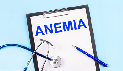 On a blue background, a stethoscope, a pen and a tablet with paper and the text ANEMIA. Medical...