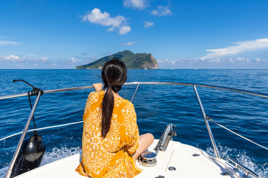 Travel woman sit on the boat and go Guishan Island and milk sea in Yilan of Taiwan