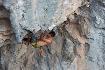 Strong man climbing a rock.