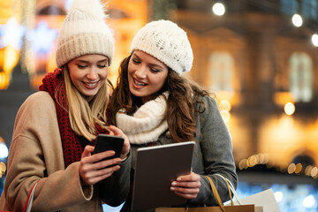Happy women friends looking at digital tablet PC. People shopping online technology tourism concept