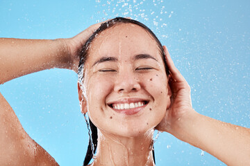 Woman, shower and smile for skincare hygiene, wash or cleanse against a blue studio background....