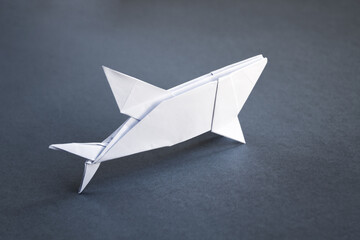 White paper shark origami isolated on a grey background