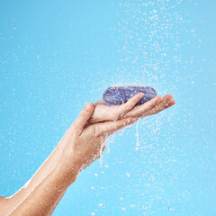 Shower, soap and woman hands in a studio to wash her hands or body for hygiene, wellness or health. Water, clean and closeup of model holding soap bar for self care while isolated by blue background.
