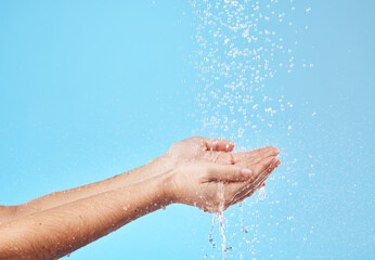 Shower, water and hands of a woman cleaning, saving and catching liquid against blue studio...
