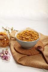 Noodle and Fried Onions ready to eat for garnish on the chopping board and spoon on the top view . Copy space for text