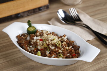 Filipino pork sisig with kalamansi on a table