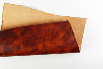A roll of brown leather on a white background.
