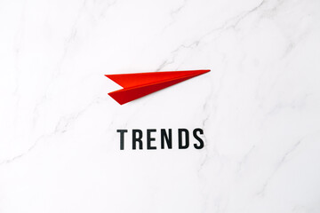 Global World Trends, Top New trends, forecasting. Word trends and red paper plane on red background.