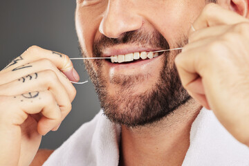 Floss, dental hygiene and man cleaning teeth, for wellness and against grey studio background. Oral...