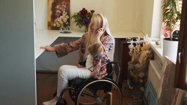 A cute fair-haired girl in a wheelchair, wearing headphones, dances and sings