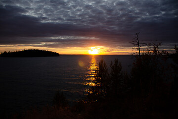 The sun sets behind the lake and reflects a beautiful sunny path. Horizontal photo of a beautiful sunset