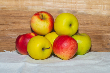 Apples lying on a white tablecloth. Still life of seven apples.