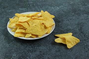 White plate with corn chips nachos on the concrete background. Mexican nachos.