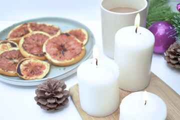 Christmas card burning candles fried oranges cones Christmas tree toys and a mug of coffee on the windowsill on a winter day