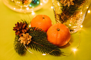 Fototapeta na wymiar New Year's composition with a vase, tangerines, spruce cones. Christmas mood