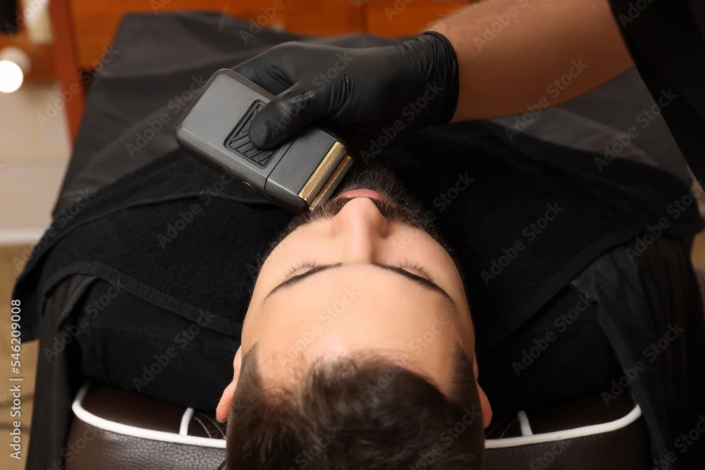 Canvas Prints Professional hairdresser working with client in barbershop, closeup