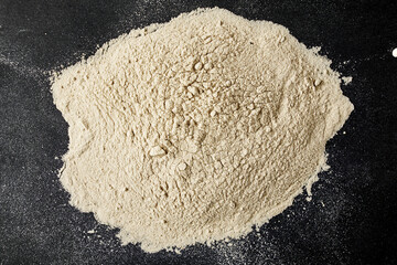 black salt Kala namak finely ground scattered on a black background