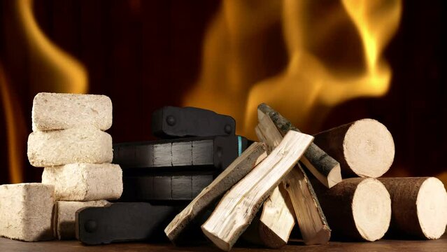 Kaminholz mit, Kohle mit Holz-, Briketts und Kaminfeuer als Hintergrund