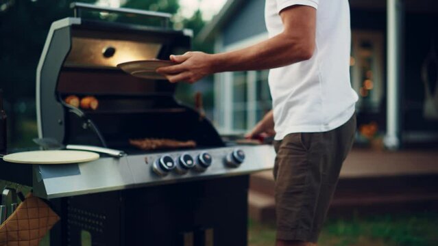 Handsome Man Bringing Prepared Grilled Meat to the Otherwise Vegetarian Table with Family Members and Friends. Diverse Group of Adults and Children Having an Outdoors Dinner Celebration.