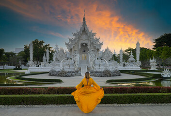 Wat Rong Khun or White Temple at sunset. Tourist girl looking towards the temple. Thailand's top...
