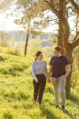 Fototapeta premium A young couple in love walks in the woods, having a good time together