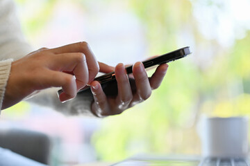 Close-up shot, A female hands holding her smartphone, typing on screen