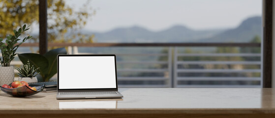 Notebook laptop mockup and copy space on tabletop over blurred window background.