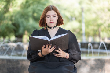 girl reads a book in the park outdoors.