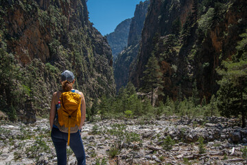 A hiker with a backpack enjoys the view in the Samaria Gorge on the Greek island of Crete