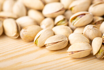 Close up shot of pistachios on wooden table. Tasty salted pistachios, macro photo