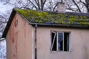 Fototapeta na wymiar Abandoned, vandalized residential building. Broken glass, slum, desolation. Defocused.