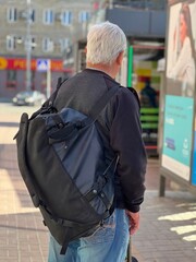 Senior man with backpack in the city.