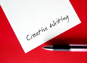 Pen writing on notebook CREATIVE WRITING, means writing with imaginative approach to subject matter...