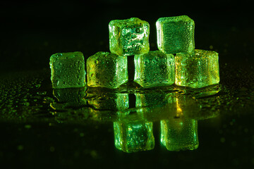 Green ice cubes on black background.