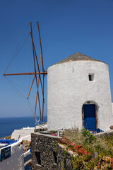 Fototapeta na wymiar Traditional white windmill in Oia on the island of Santorini. Cyclades, Greece