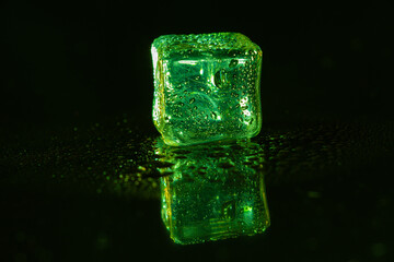 Green ice cubes on black background.