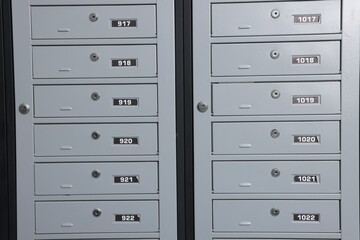 Closed metal mailboxes with keyholes and sequence numbers indoors