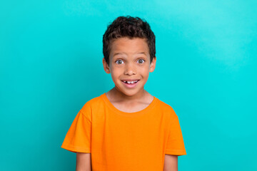 Photo of good mood excited little guy dressed orange t-shirt smiling isolated teal color background