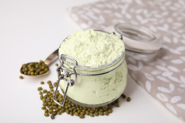 Glass jar of flour and mung beans on white table