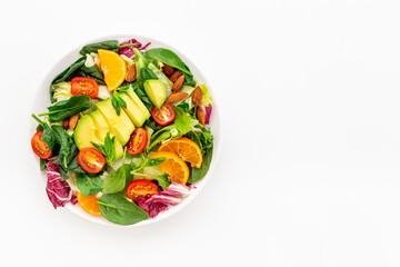 Top view of served green salad with avocado and tomatoes