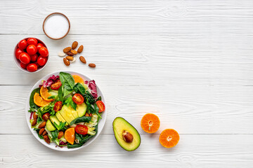 Healthy vegetarian bowl of green salad with avocado and tomatoes