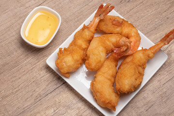 Battered shrimp with plum sauce in white plate